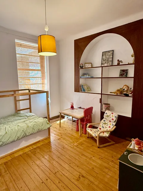 Children's bedroom with a bunk bed, reading nook and toy shelves