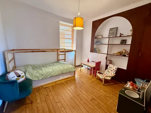 A wider view of the children's bedroom, with bunk bed and play table