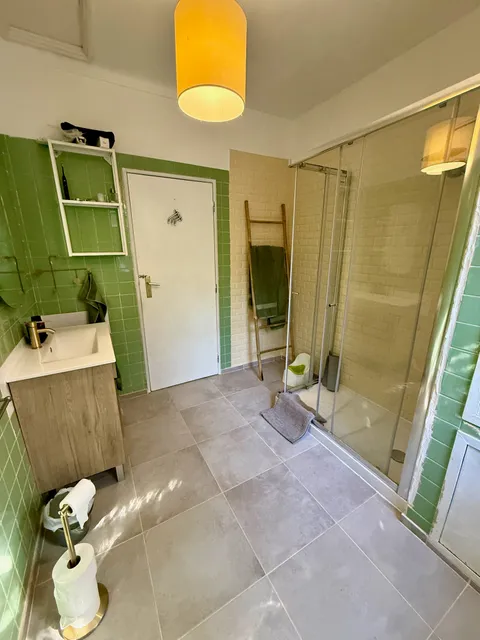 A green-tiled bathroom with a walk-in shower